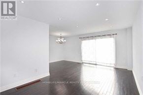 Brampton (Brampton North) apartment for rent - A spacious room with wooden floors and a chandelier.