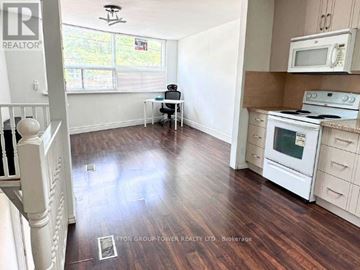 Toronto (Birchcliffe-Cliffside) apartment for rent - A kitchen with white cabinets and a wooden floor.