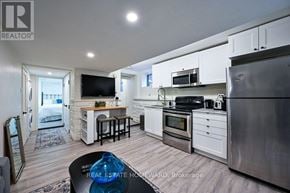 Toronto (South Riverdale) apartment for rent - A modern kitchen with stainless steel appliances and white cabinets.