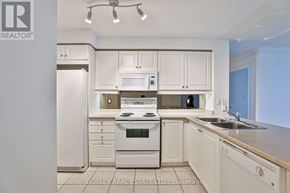 Toronto (Mimico) condo for rent - A kitchen with white cabinets and appliances.