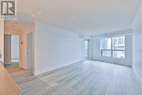 Toronto (Mimico) condo for rent - A large, empty room with wooden floors and white walls.