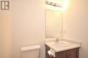 Guelph (Grange Road) townhouse for rent - A white toilet sits next to a sink in a small bathroom.