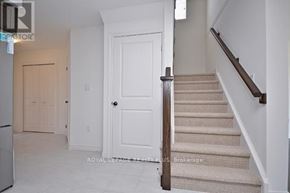 Guelph (Grange Road) townhouse for rent - A white door is in a hallway with a staircase.