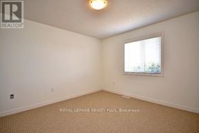 Guelph (Grange Road) townhouse for rent - A white room with a window and carpeting.