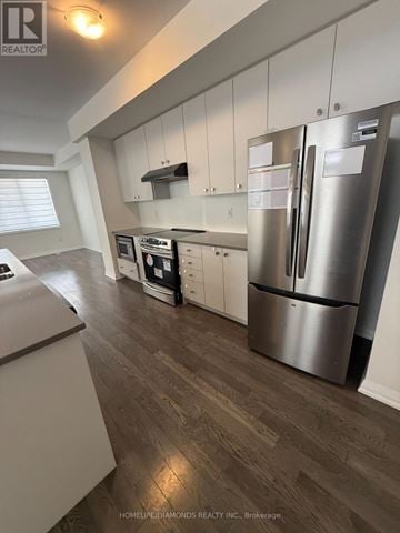 Haldimand townhouse for rent - A kitchen with a refrigerator, microwave, and oven.