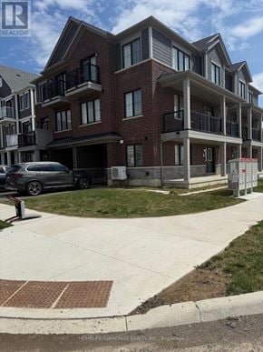 Haldimand townhouse for rent - A multi-story apartment building with a car parked in front.