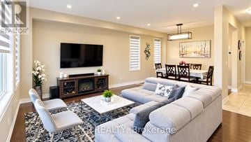 Waterloo apartment for rent - A living room with a grey sofa, a white coffee table, and a television on the wall.