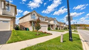 Waterloo apartment for rent - A real estate brokerage sign is displayed on a pole in front of a row of houses.