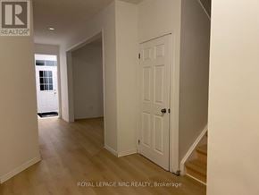 Niagara Falls (Brown) apartment for rent - A white door is in a room with wooden floors and white walls.