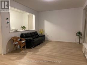 Niagara Falls (Brown) apartment for rent - A living room with a black couch and a wooden chair.