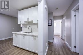 Aylmer fourplex for rent - A white kitchen with a sink and cabinets.