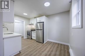 Aylmer fourplex for rent - A kitchen with white cabinets and a refrigerator.