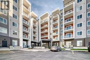 Calgary apartment for rent - A large apartment complex with a car parked in front.