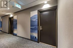 Toronto (Annex) condo for rent - A hallway with a door on the right and a painting of a beach on the wall.