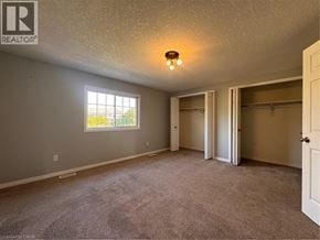 Kitchener townhouse for rent - A room with a window and a carpeted floor.