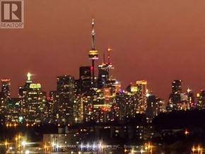Toronto (Bendale) condo for rent - A city skyline at night with the CN Tower prominently lit up.