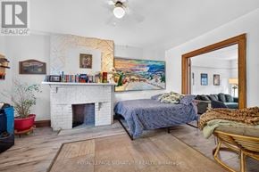 Toronto (South Riverdale) apartment for rent - A bedroom with a fireplace and a painting on the wall.