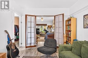 Toronto (South Riverdale) apartment for rent - A living room with a guitar, a chair, and a bookshelf.