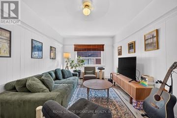 Toronto (South Riverdale) apartment for rent - A living room with a green couch and a guitar.