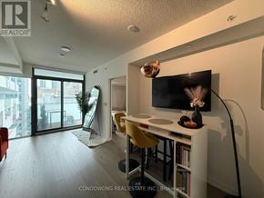 Toronto (Church-Yonge Corridor) condo for rent - A modern living room with a television, a desk, and a chair.