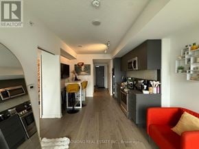 Toronto (Church-Yonge Corridor) condo for rent - A modern kitchen with a red couch and a bar stool.