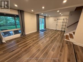 Newmarket (Gorham-College Manor) apartment for rent - A spacious room with wooden flooring and a staircase on the right side.
