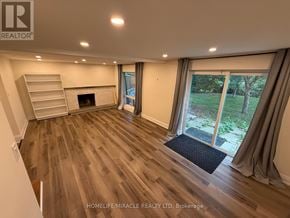 Newmarket (Gorham-College Manor) apartment for rent - A spacious room with wooden flooring and a fireplace.