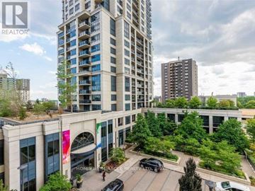 Toronto (Etobicoke West Mall) condo for rent - A tall building with a balcony on the 10th floor is surrounded by other buildings and trees.