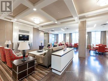 Toronto (Etobicoke West Mall) condo for rent - A well-lit, modern living room with a large sofa set and a television.