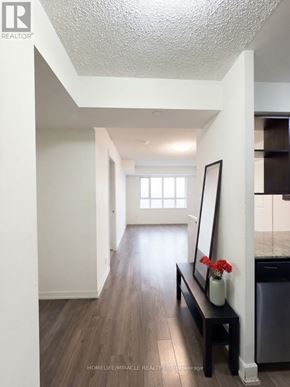 Toronto (Etobicoke West Mall) condo for rent - A hallway with a bench and a vase of flowers.