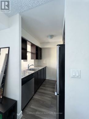 Toronto (Etobicoke West Mall) condo for rent - A kitchen with a black fridge and a black counter top.