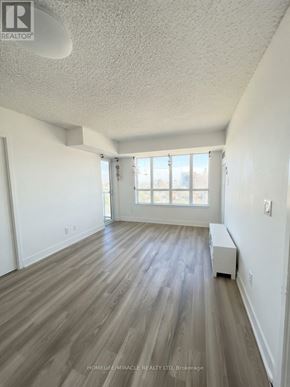Toronto (Etobicoke West Mall) condo for rent - A room with wooden flooring and a window.