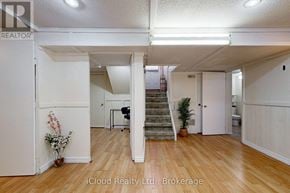 Brampton (Fletcher's West) apartment for rent - A spacious room with wooden floors and white walls, featuring a staircase and a dining area.
