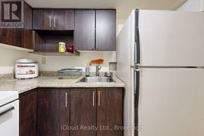 Brampton (Fletcher's West) apartment for rent - A kitchen with wooden cabinets and a white refrigerator.