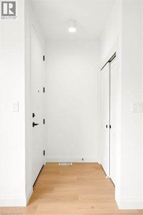 Kitchener apartment for rent - A hallway with a wooden floor and white walls.