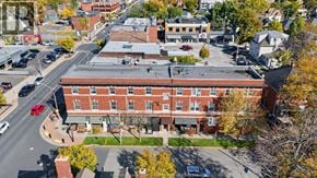 Windsor apartment for rent - A red brick building with a parking lot in front.