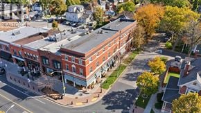 Windsor apartment for rent - A street view of a town with a red brick building in the center.