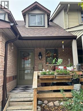 Guelph townhouse for rent - A house entrance with a wooden railing and a glass door.