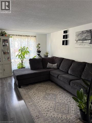Guelph townhouse for rent - A living room with a grey couch and a rug.