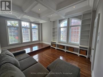 Toronto (Palmerston-Little Italy) duplex for rent - A living room with grey couches and a large window with blinds.
