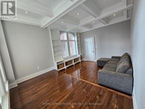 Toronto (Palmerston-Little Italy) duplex for rent - A spacious living room with hardwood floors and a high ceiling.