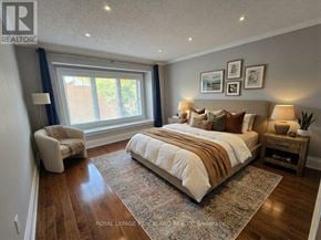 Toronto (Palmerston-Little Italy) duplex for rent - A bedroom with a large bed and a chair by the window.
