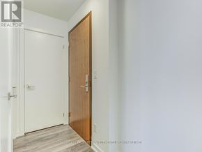 Toronto (Henry Farm) condo for rent - A wooden door is in the middle of a white hallway.