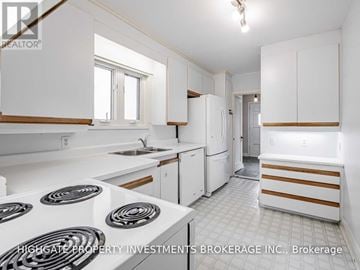 Toronto (Leaside) apartment for rent - A white kitchen with a stove top oven and a refrigerator.