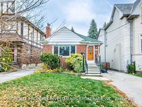Toronto (Leaside) apartment for rent - A house with a green lawn and a brown door.