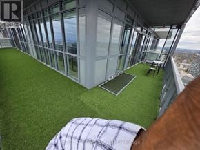 Toronto (Bay Street Corridor) condo for rent - A balcony with a table and chairs overlooking a cityscape.