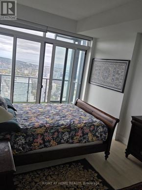 Toronto (Bay Street Corridor) condo for rent - A bedroom with a large bed and a view of the city.