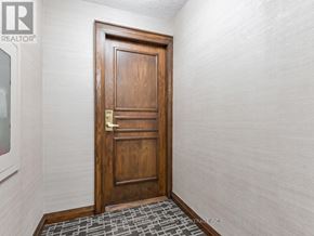 Toronto (Mount Pleasant West) condo for rent - A wooden door with a brass handle in a room with white walls.