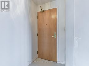 Toronto (Mount Pleasant West) condo for rent - A wooden door with a brass handle in a white room.