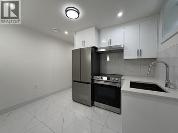 Vancouver apartment for rent - A modern kitchen with a black refrigerator and stove.